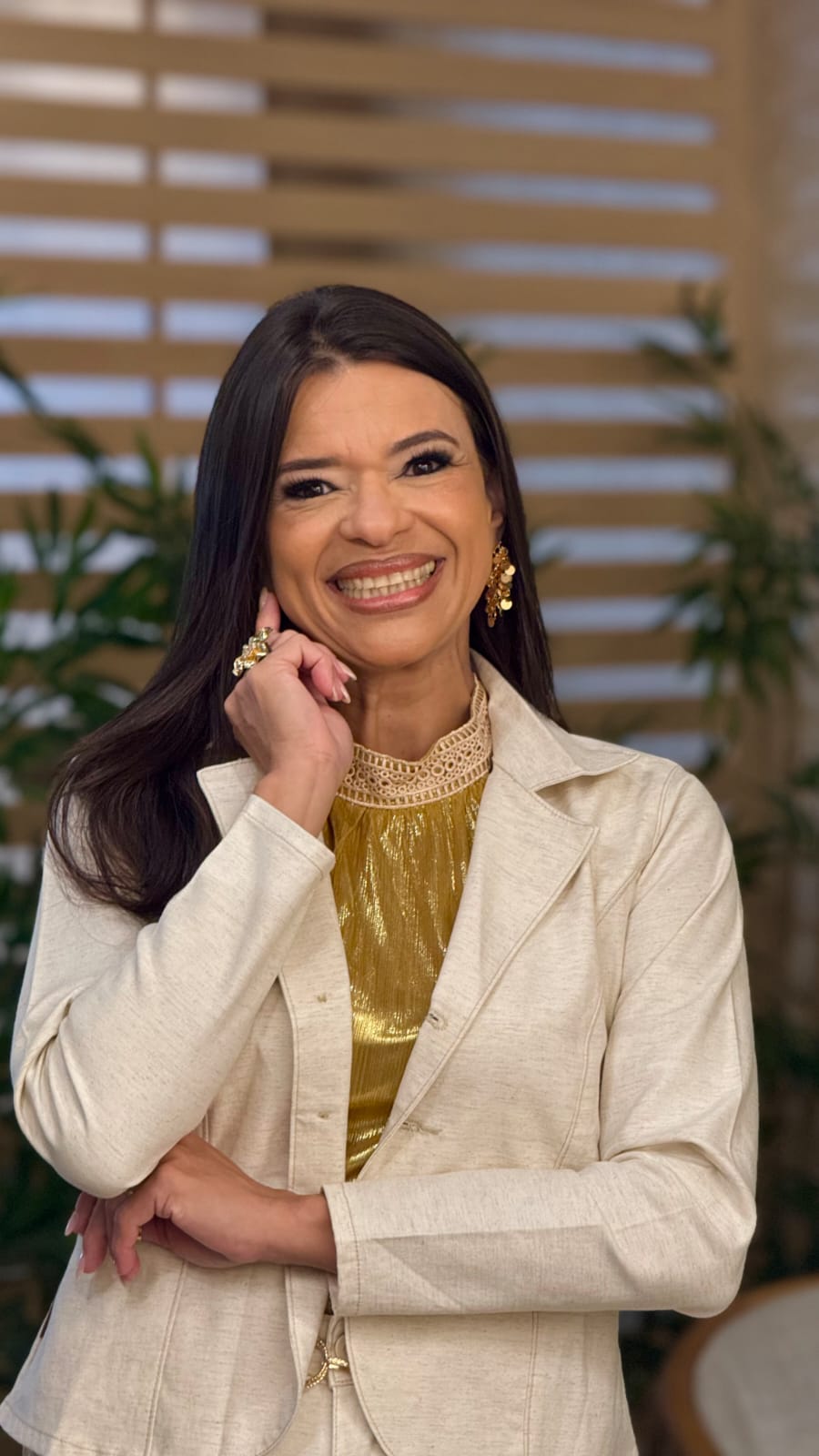Lorena Da Rós sorrindo, com a mão apoiada no rosto